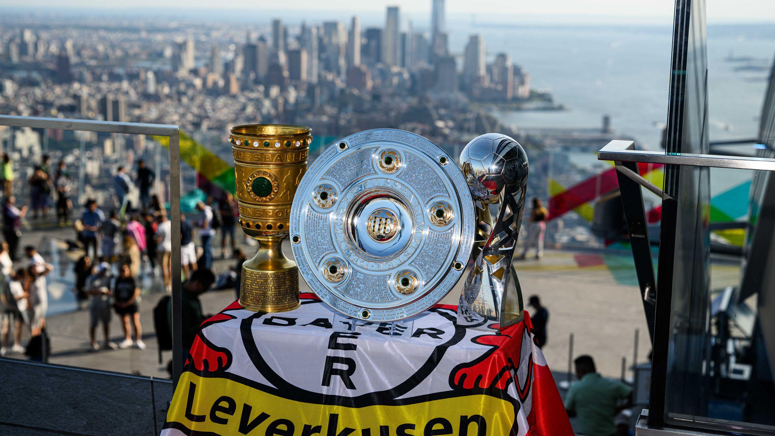 A picture of the trophies with the New York skyline in daylight in the background